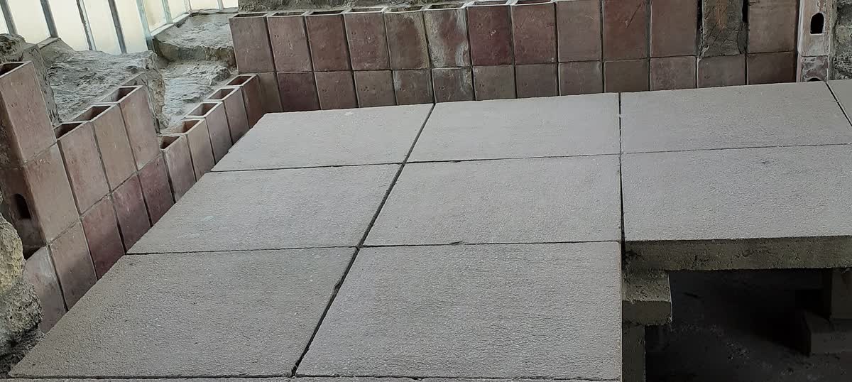 Reconstrucción de un hipocausto: la losa del piso apoyada sobre pilares de ladrillo, y los conductos verticales en la pared