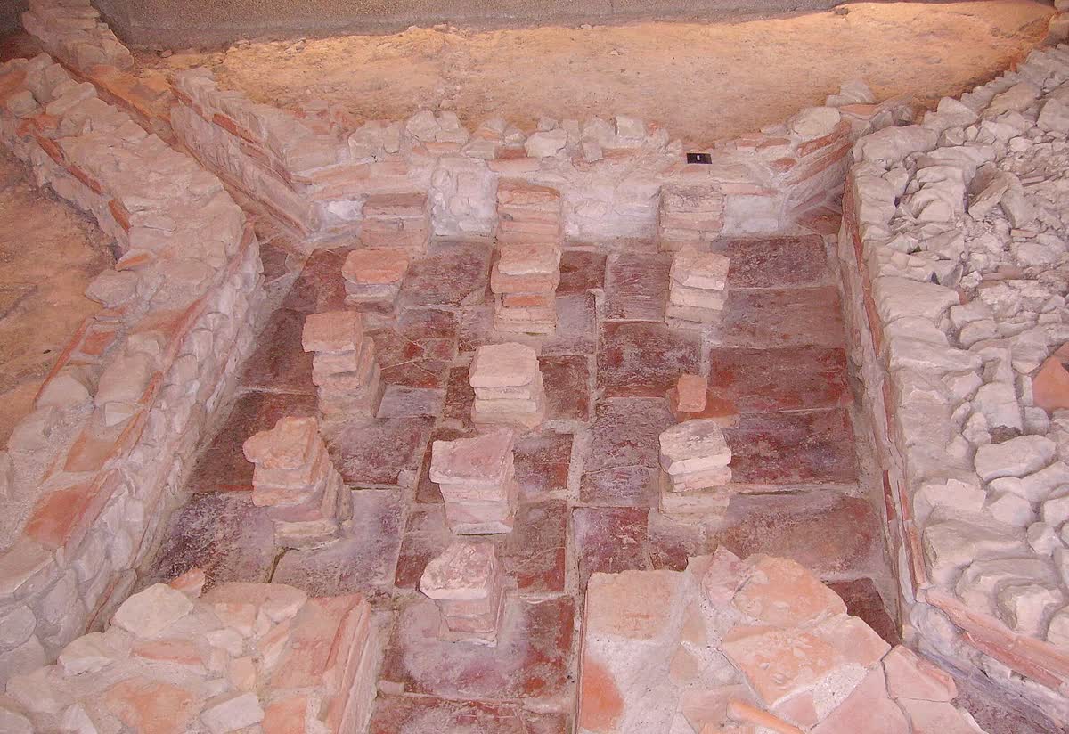 Pilae de ladrillo apiladas bajo el piso de un hipocausto excavado