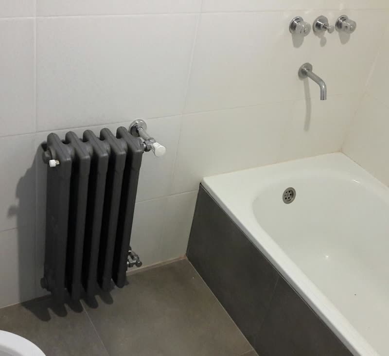 Radiador de fundición junto a la bañera